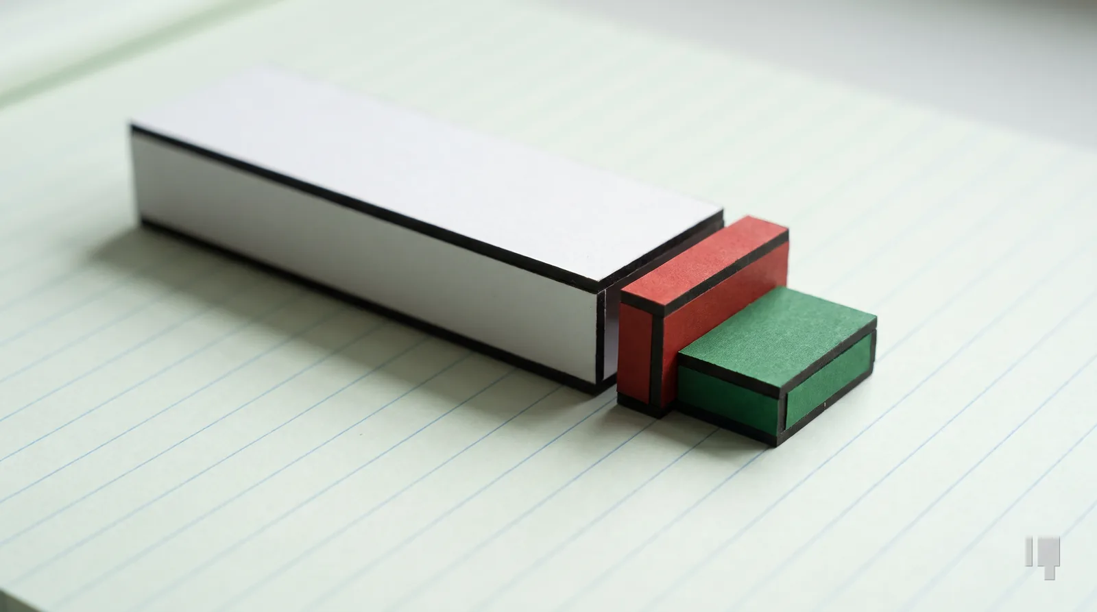 A card block with a red slice cut from its end, a green block beneath